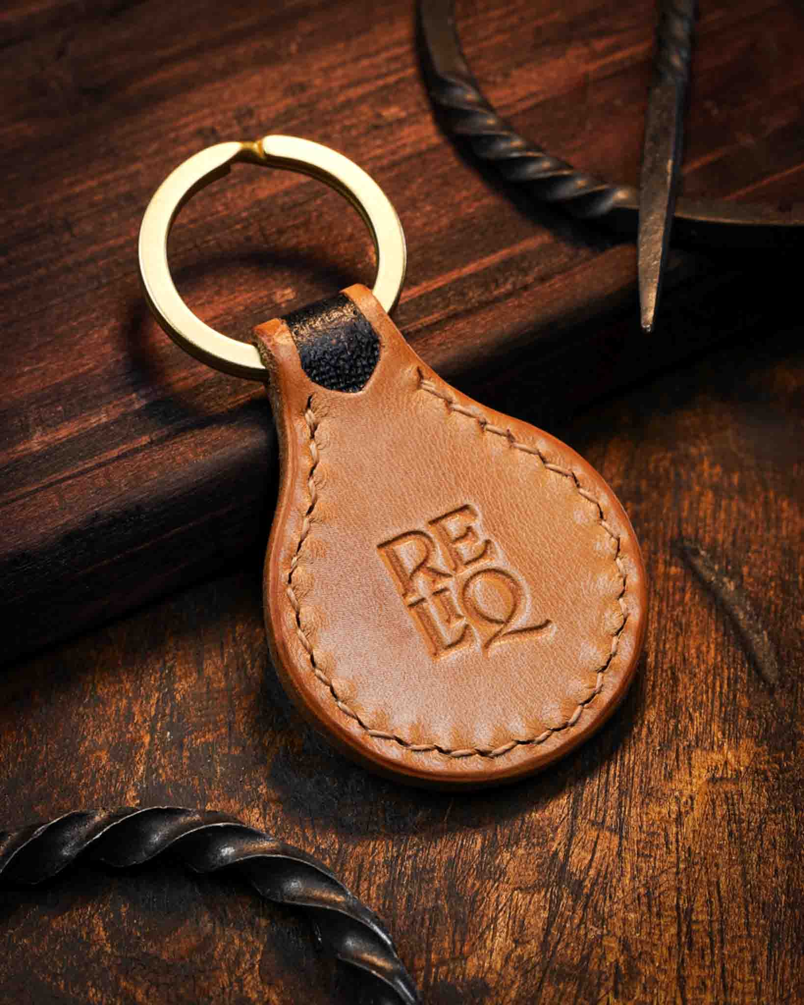 Back view of a handmade medieval leather keyring featuring smooth tanned leather, detailed saddle stitching, and the stamped Reliq workshop logo.
