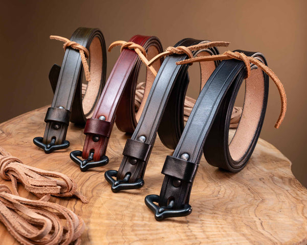 Assortment of authentic medieval leather belts in various colors, showcasing the hand-finished leather straps and period-accurate black metal hardware.