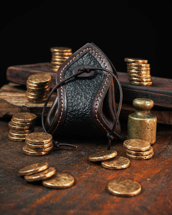 Dark brown handmade leather coin pouch featuring a textured front panel and stitched edges, secured with a custom leather drawstring.