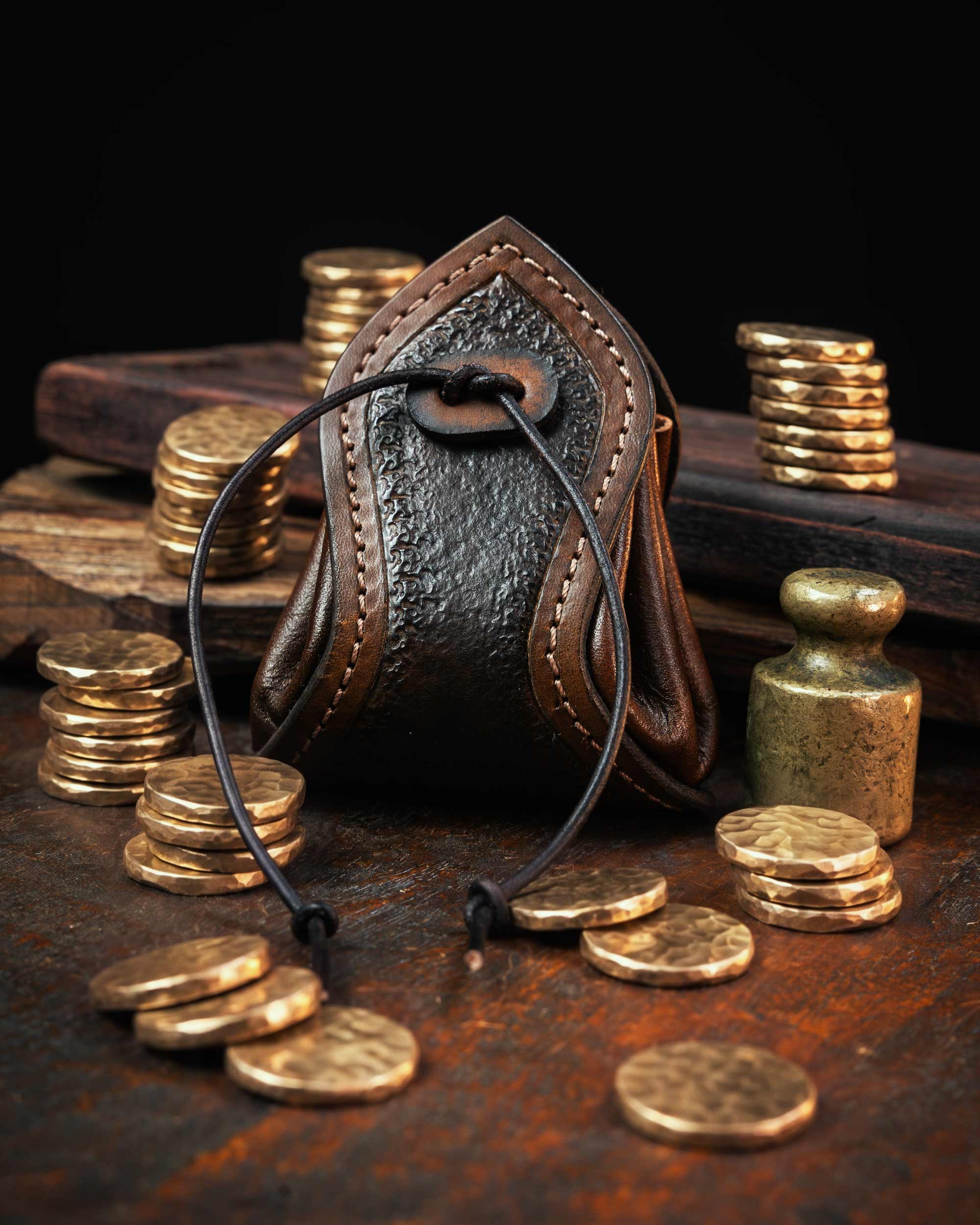 brown handmade leather coin pouch featuring a textured front panel and stitched edges, secured with a custom leather drawstring.