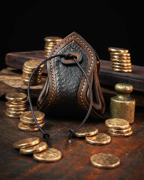 brown handmade leather coin pouch featuring a textured front panel and stitched edges, secured with a custom leather drawstring.