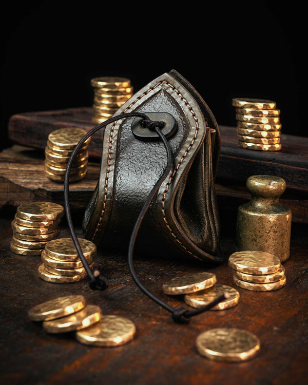 Olive green artisan leather drawstring pouch, showcasing textured leathercraft and stitching, styled as an authentic medieval coin purse.
