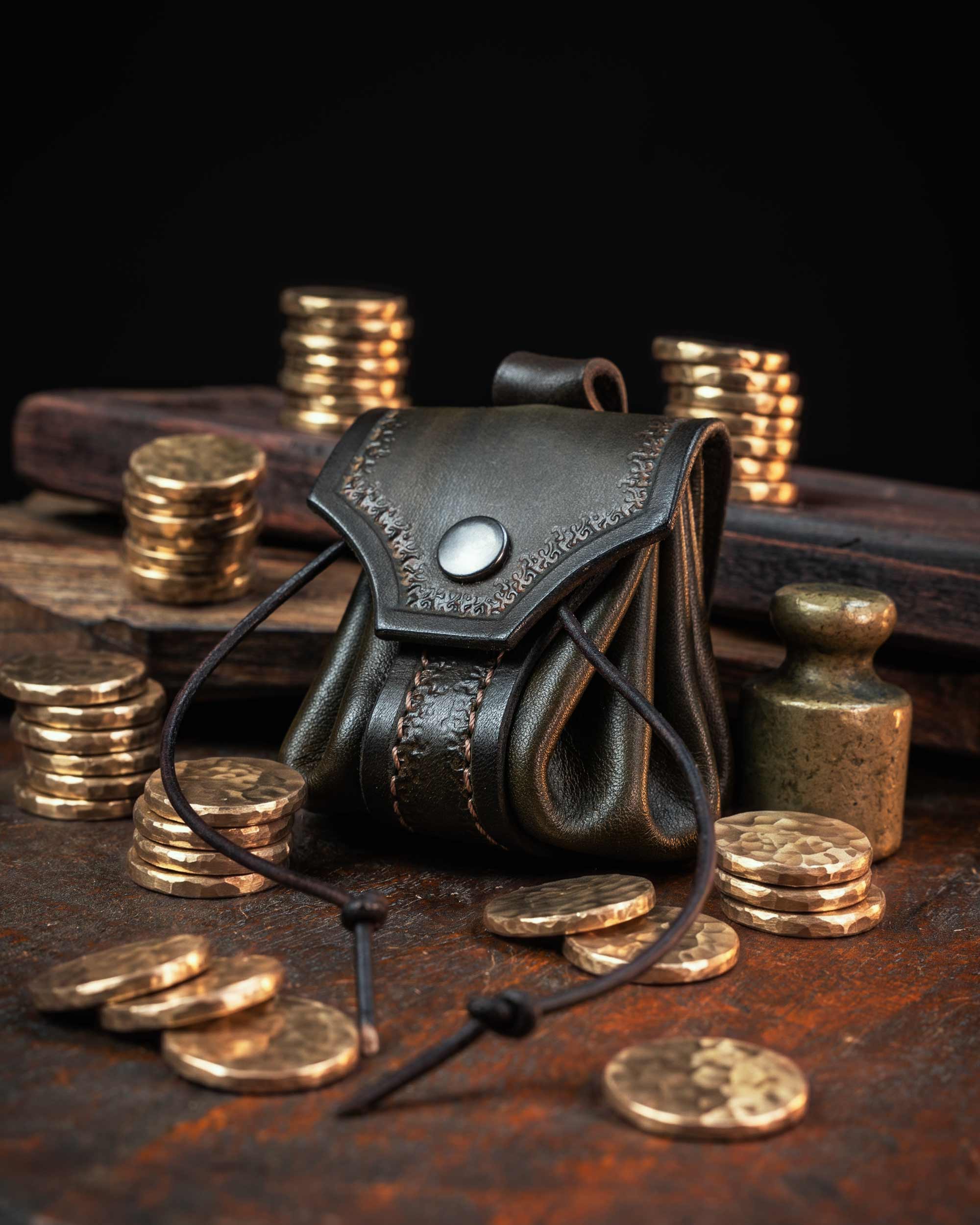 Olive green artisan leather drawstring pouch, showcasing textured leathercraft and stitching, styled as an authentic medieval coin purse.