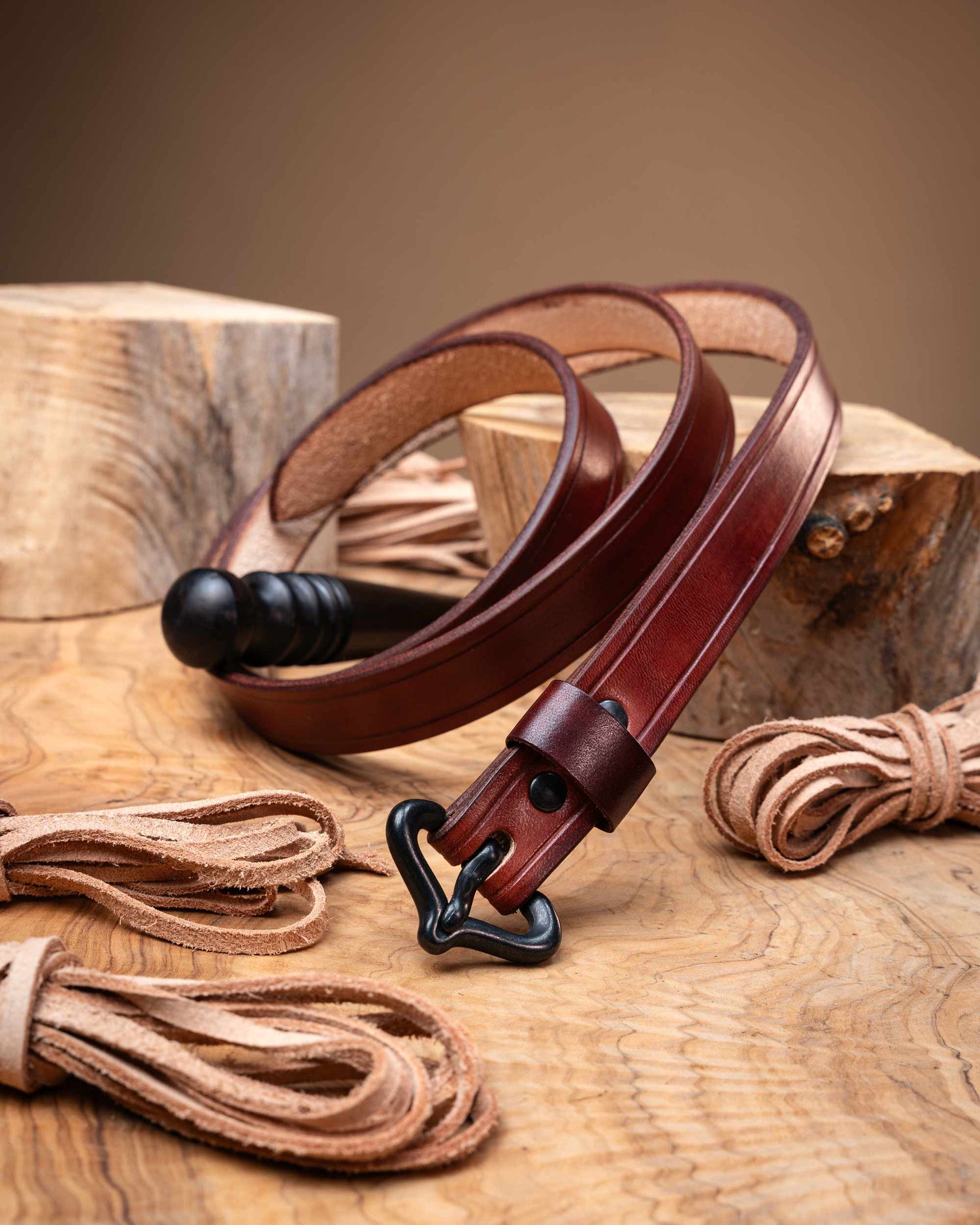 Rustic reddish-brown artisan leather belt for medieval reenactment, detailed with edge grooves and a historically inspired black buckle.