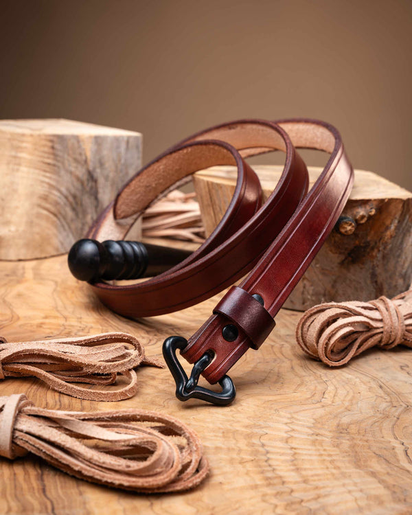 Rustic reddish-brown artisan leather belt for medieval reenactment, detailed with edge grooves and a historically inspired black buckle.