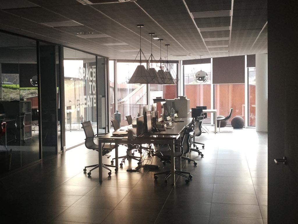 A dark, empty office with 'SPACE TO CREATE' written on the glass, symbolizing the starting point of the Reliq journey