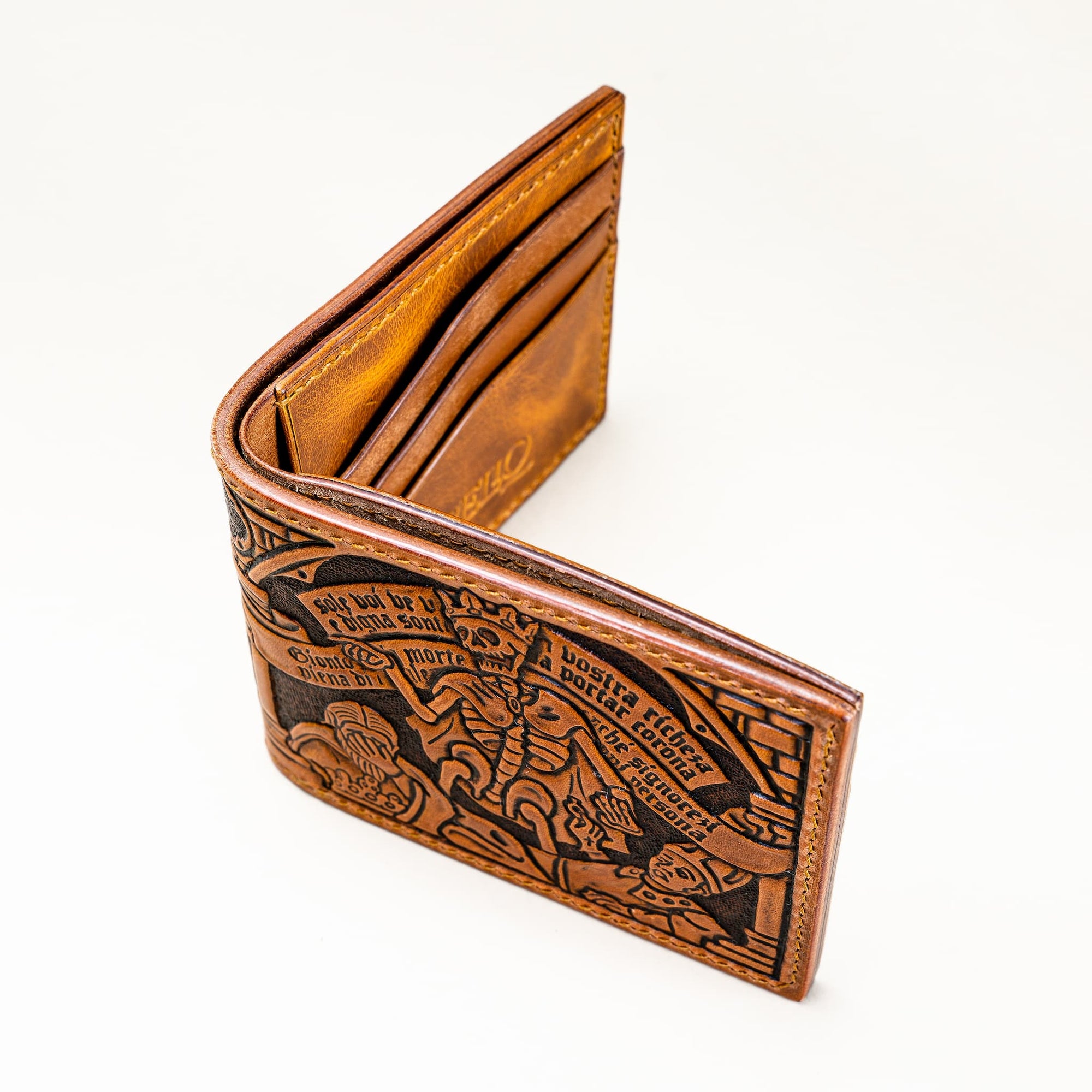 Angled view of the Reliq Leather Trionfo della Morte hand-tooled wallet, showing the crowned skeleton and figures inspired by the 1485 fresco in Clusone.