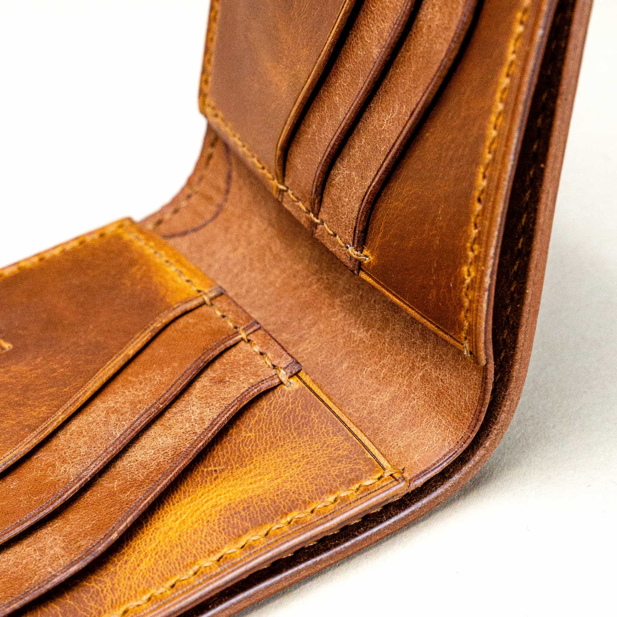 Macro detail of the Trionfo della Morte handmade wallet interior by Reliq Leather. Vegetable-tanned leather with hand stitching and natural patina.