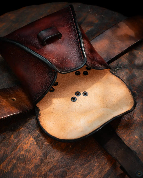 Open mahogany leather pouch bag showing full-grain suede interior and contoured anti-spill side gussets