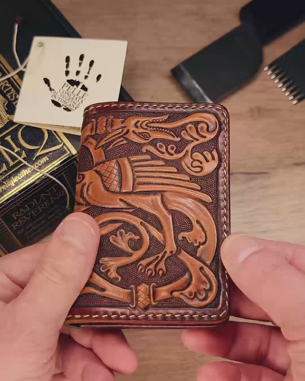 Handmade leather card wallet 'The Dragon' featuring a hand-tooled medieval dragon design in relief. Dark tan exterior with green and brown leather interior card slots