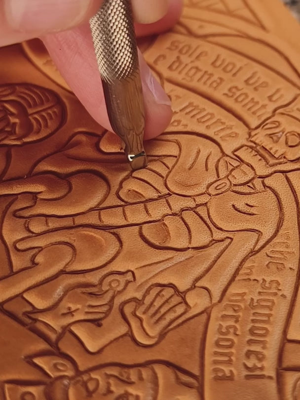 Close-up of a leatherworker carving, beveling, and backgrounding a medieval Danse Macabre skeleton figure using traditional metal hand tools