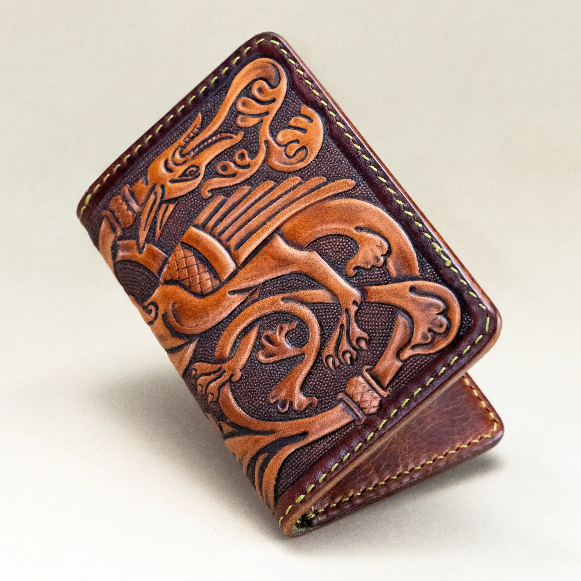 Close view of the dragon motif on the Western Dragon hand-tooled leather card holder by Reliq, crafted in the style of medieval manuscript miniatures.