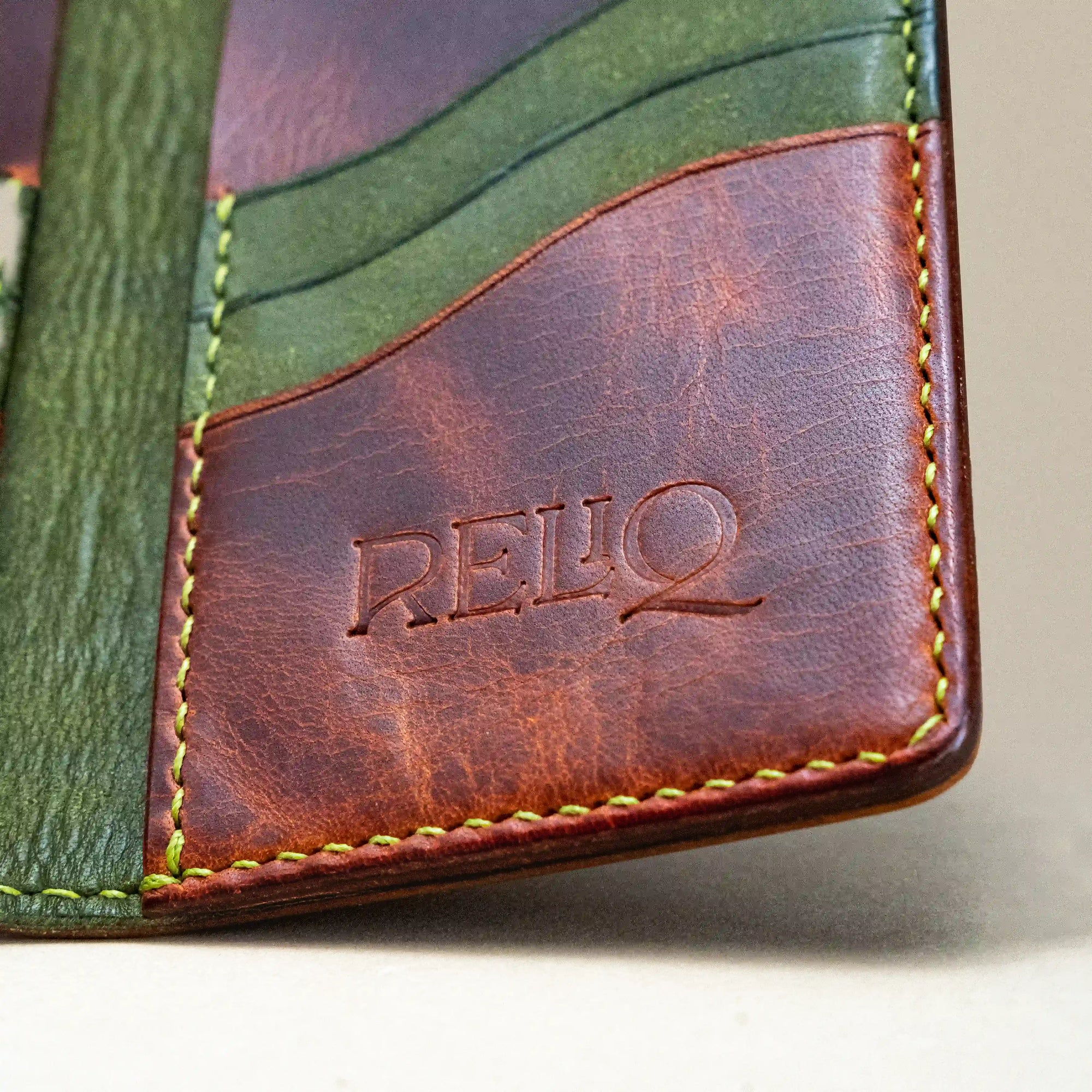 Interior detail of the Western Dragon card holder wallet by Reliq, showing green leather slots, saddle stitching, and embossed Reliq logo.