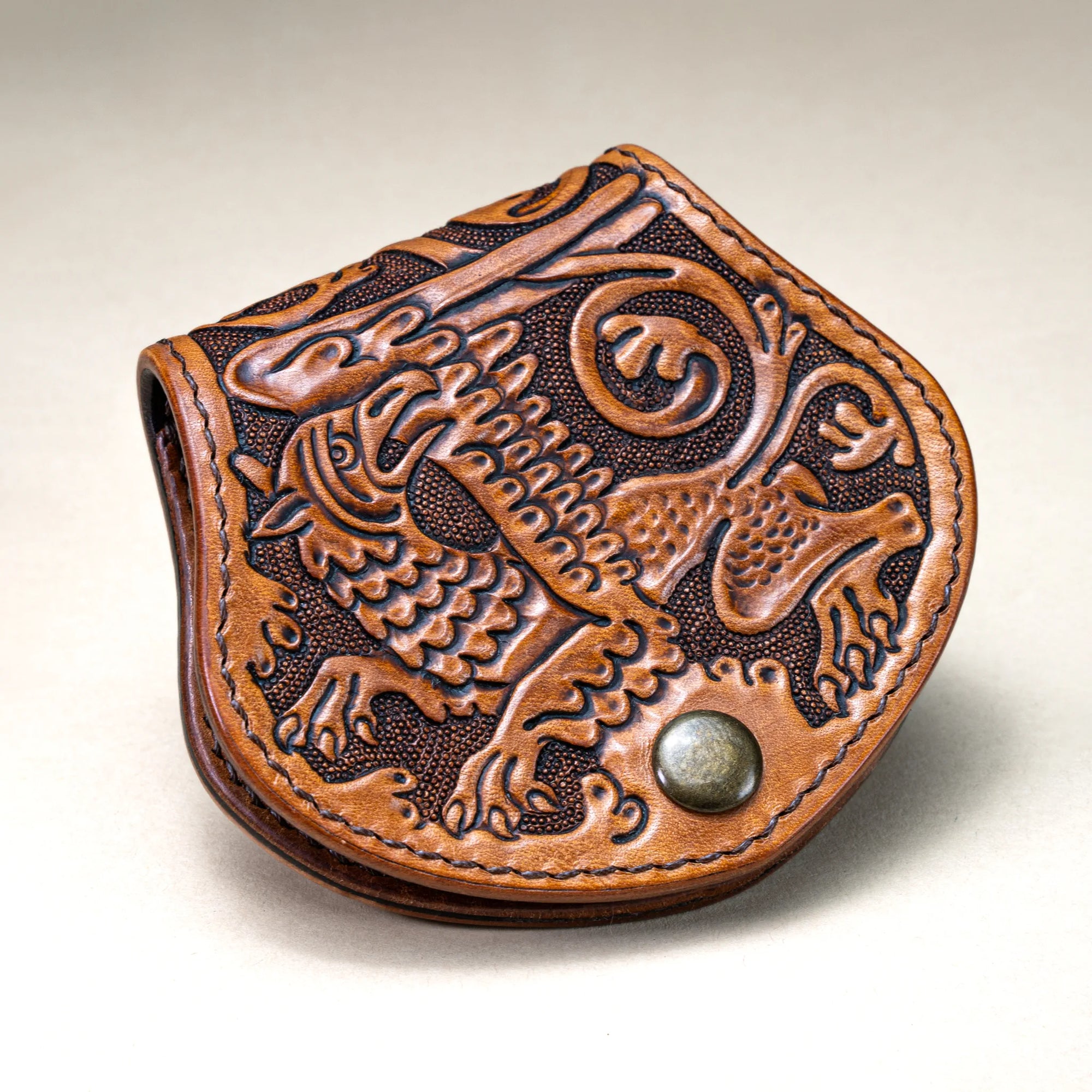Close-up shot of Reliq Leather Gryphon handmade coin purse, tooled with medieval eagle-lion motif.