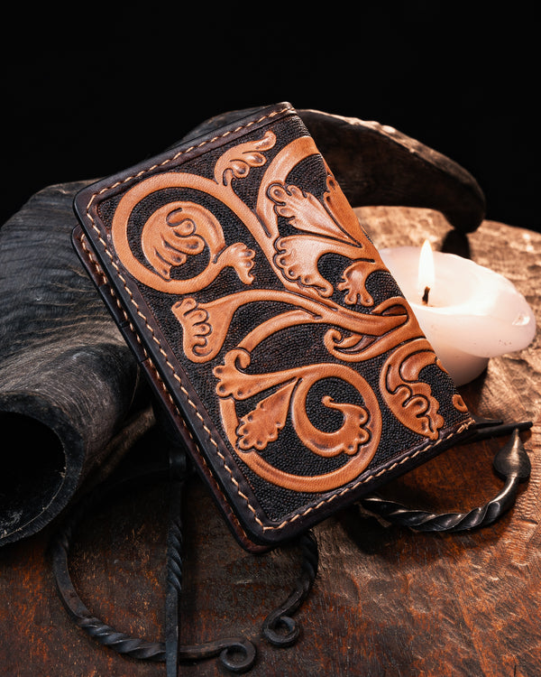 Back view of a medieval leather card holder showcasing intricate hand-carved foliate marginalia scrollwork. Hand-tooled artisan wallet with illuminated manuscript details.